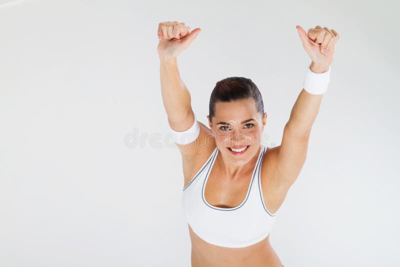 Overhead view of a young fit woman in gym clothes giving thumbs up on white background. Overhead view of a young fit woman in gym clothes giving thumbs up on white background