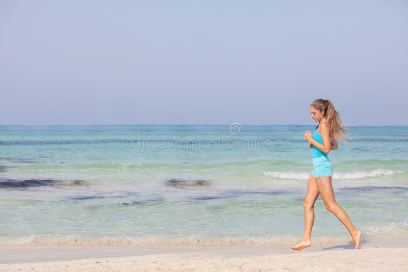 Dysponowana zdrowa kobieta jogging lub biega na seashore fotografia stock Dysponowana zdrowa kobieta jogging lub biega na seashore fotografia stock