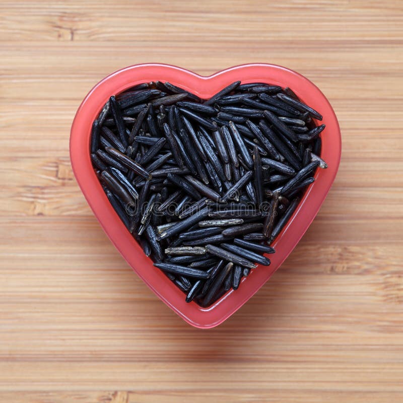 Wild rice in a heart shape bowl. Close-up. Wild rice in a heart shape bowl. Close-up.