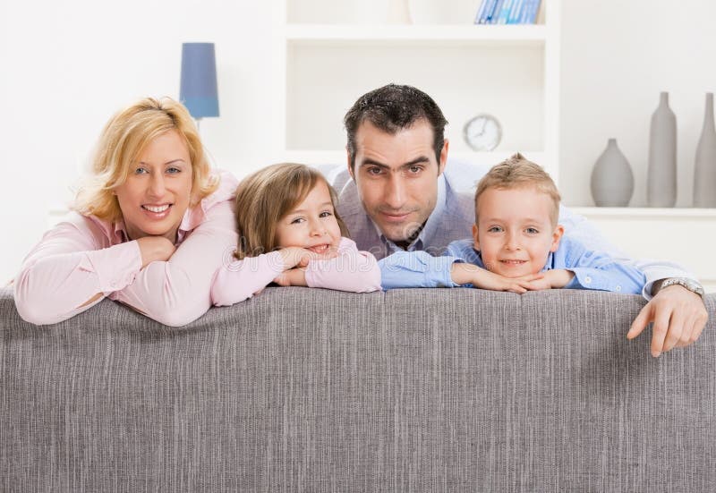 Portrait of happy couple and their two children at home, smiling. Portrait of happy couple and their two children at home, smiling.