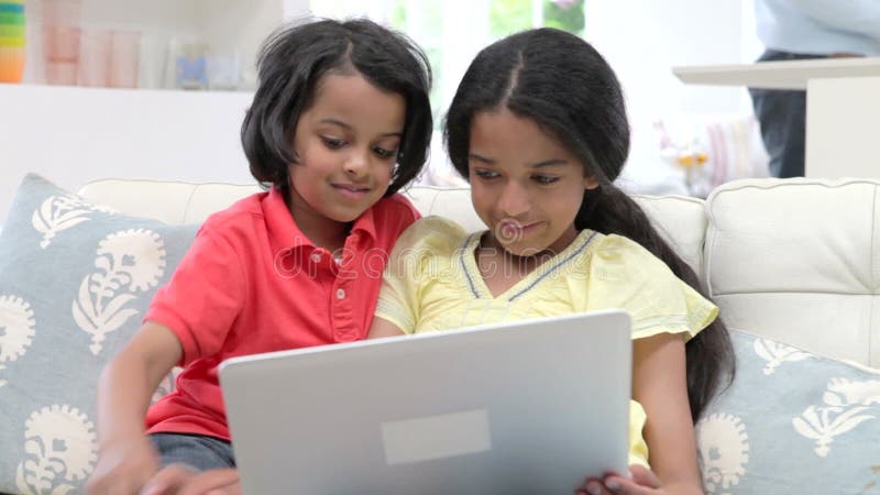 Dzieci Używa laptop Podczas gdy Siedzący Na kanapie W Domu