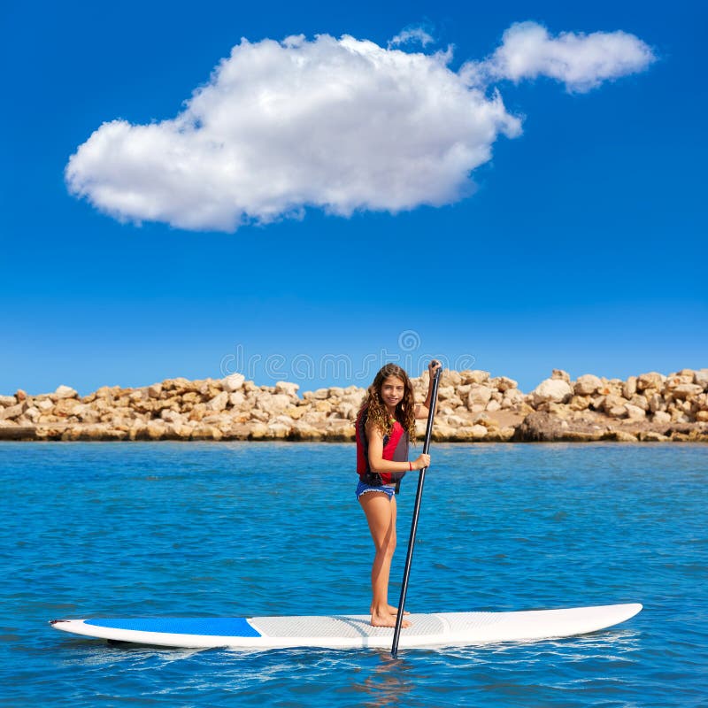 Dzieciaka paddle kipieli surfingowa dziewczyna z rzędem w plaży zdjęcia stock Dzieciaka paddle kipieli surfingowa dziewczyna z rzędem w plaży zdjęcia stock