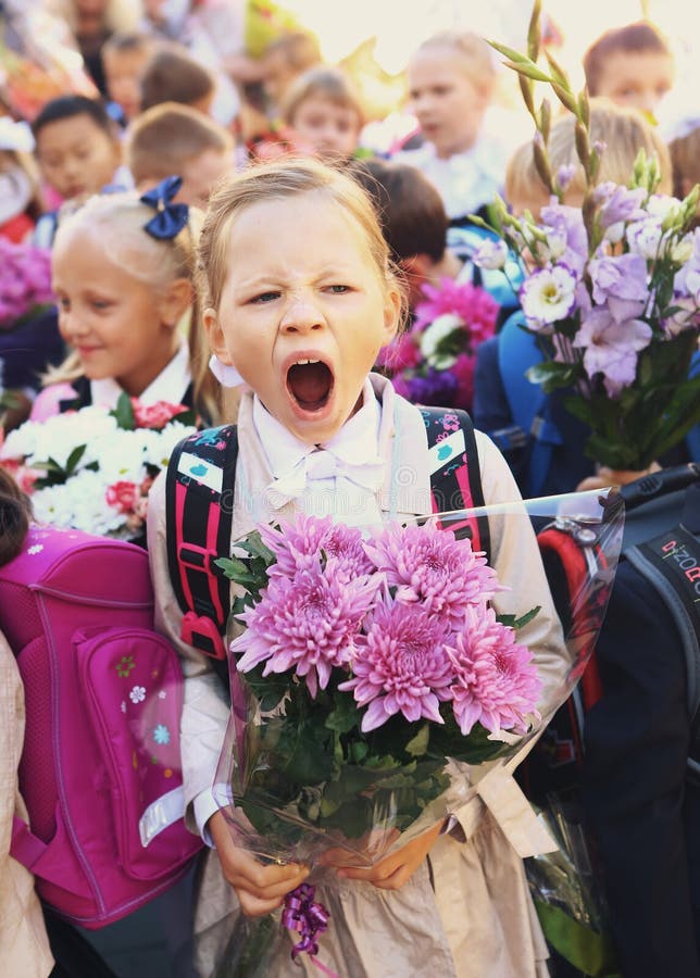 Moscow, Russia - September 1, 2016: Unidentified girls with flowers bouquet on solemn meeting of first grade kids, called the Day of Knowledge, signify the beginning of school year. Moscow, Russia - September 1, 2016: Unidentified girls with flowers bouquet on solemn meeting of first grade kids, called the Day of Knowledge, signify the beginning of school year.
