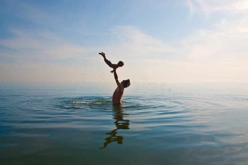 Father is tossing up a child in water. Father is tossing up a child in water