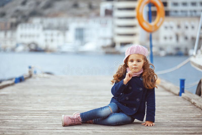 Portrait of 4 years old girl walking on berth near sea in the city, still life photo. Portrait of 4 years old girl walking on berth near sea in the city, still life photo