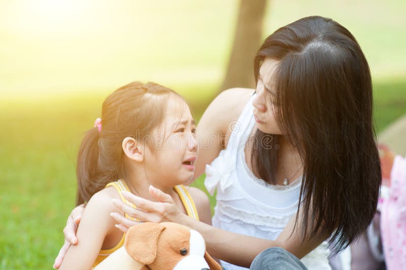 Portrait of Asian mother comforting her crying daughter in the park, Family outdoor lifestyle. Portrait of Asian mother comforting her crying daughter in the park, Family outdoor lifestyle.