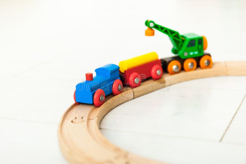 Dziecka «d drewniany pociąg na białej podłodze. Close up of a toddlers wooden train railway set