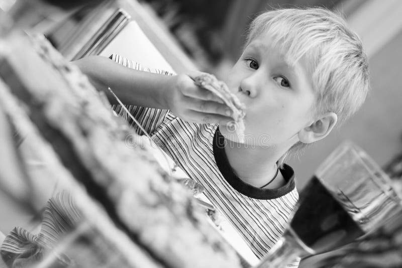 Boy eating pizza in restaurant. Focus on the face. Boy eating pizza in restaurant. Focus on the face.