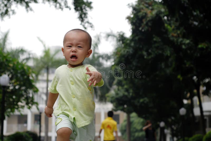 It is a cute chinese baby, he is crying and running in the outdoor. It is a cute chinese baby, he is crying and running in the outdoor.