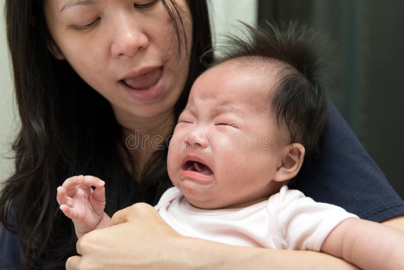 Mother is trying to comfort crying baby. Mother is trying to comfort crying baby