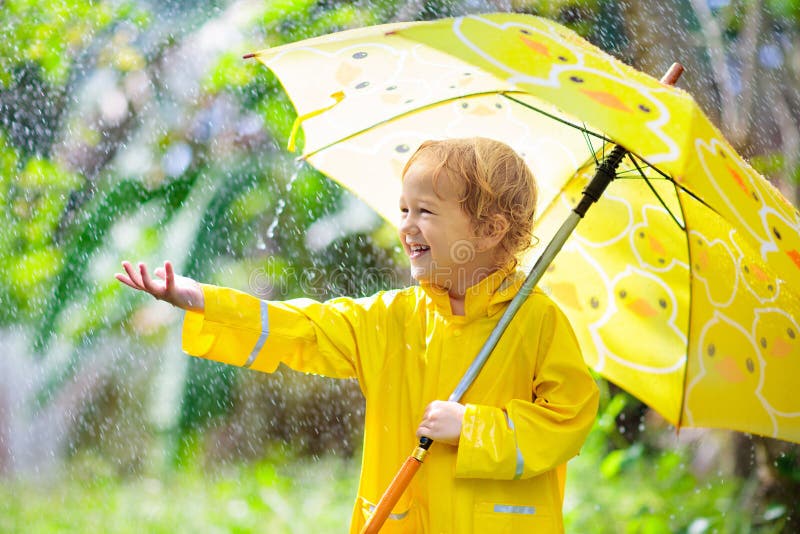 Dziecko bawi? si? w deszczu Dzieciak z parasolem