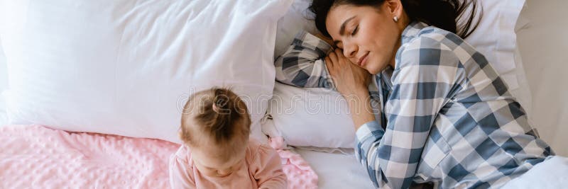 Dziecko bawiące się zabawkami, podczas gdy jej matka śpi źle w domu