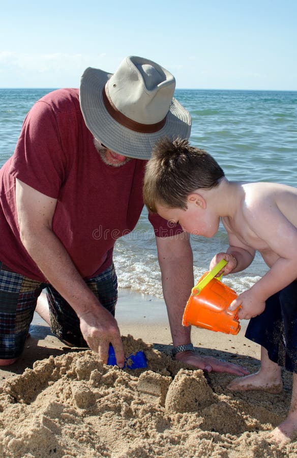 Dziecko bawić się z dziaduniem na Indiana plaży zdjęcia stock Dziecko bawić się z dziaduniem na Indiana plaży zdjęcia stock