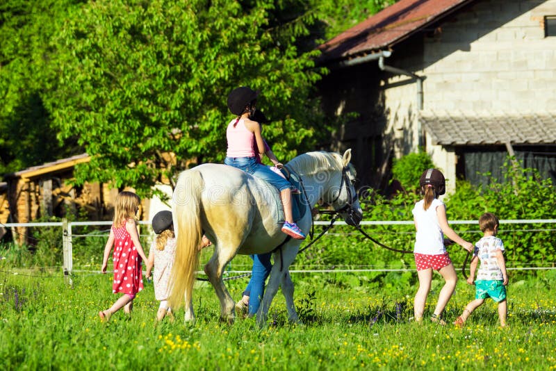 Children riding a horse at a school for horse-riding. Children riding a horse at a school for horse-riding