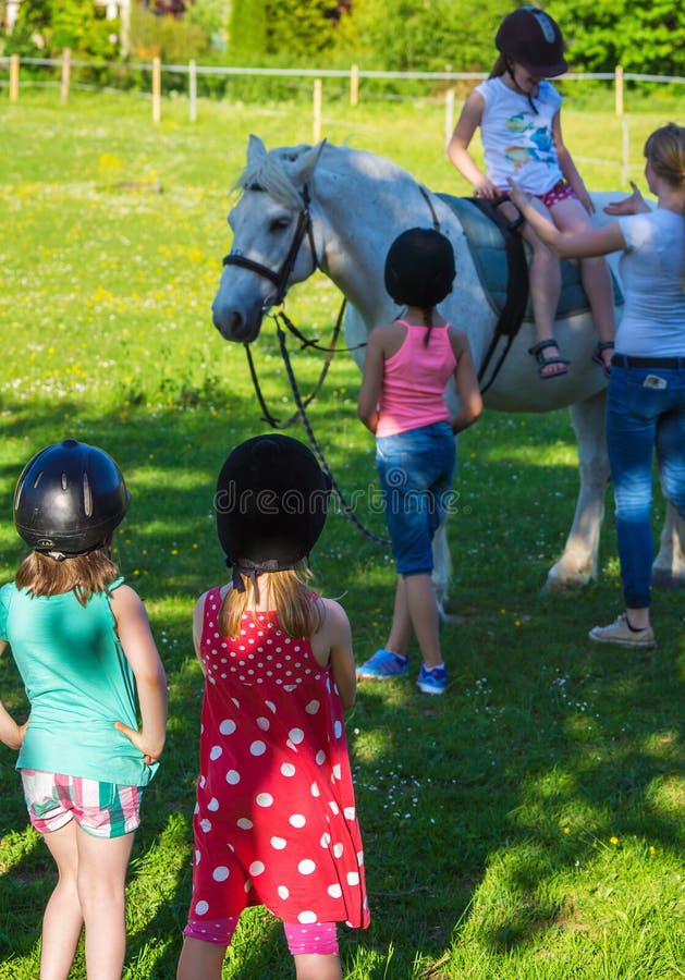 Children riding a horse at a school for horse-riding. Children riding a horse at a school for horse-riding