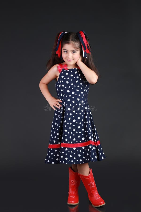 A young girl dress in US flag pattern and shows her patriotism to the USA on 4th of July. A young girl dress in US flag pattern and shows her patriotism to the USA on 4th of July.