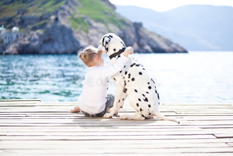 Happy babygirl with her dog on berth in summer. Happy babygirl with her dog on berth in summer