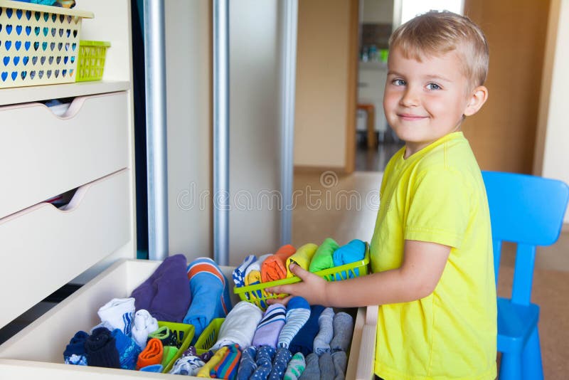 The child puts his clothes on. The boy pulls the T-shirt. The child puts his clothes on. The boy pulls the T-shirt