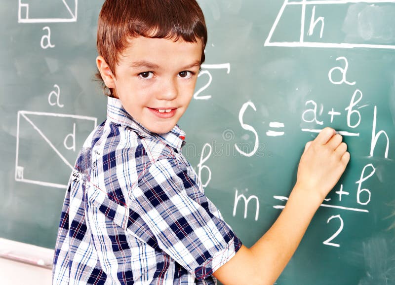 Dziecko w wieku szkolnym writing na blackboard. obrazy stock Dziecko w wieku szkolnym writing na blackboard. obrazy stock