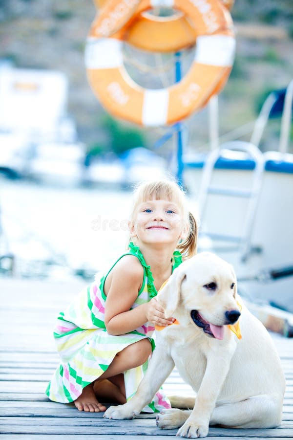 Happy babygirl with her dog on berth in summer. Happy babygirl with her dog on berth in summer