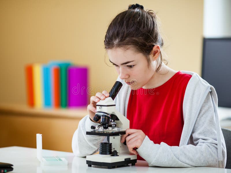 Dziewczyna badająca preparat pod mikroskopem