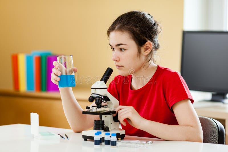 Dziewczyna badająca preparat pod mikroskopem