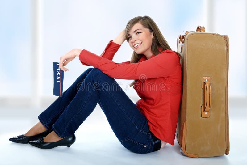 Dziewczyna blisko siedzącej walizki