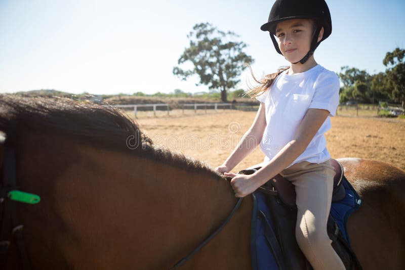 Girl riding a horse in the ranch on a sunny day. Girl riding a horse in the ranch on a sunny day