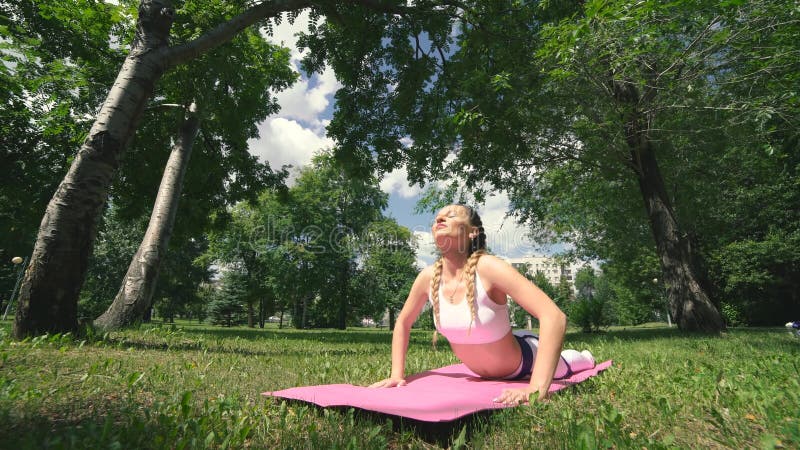 Dziewczyna medytuje Fachowy joga ćwiczy w parku robi oddychaniu ćwiczy Młoda brunetki kobieta ćwiczy joga