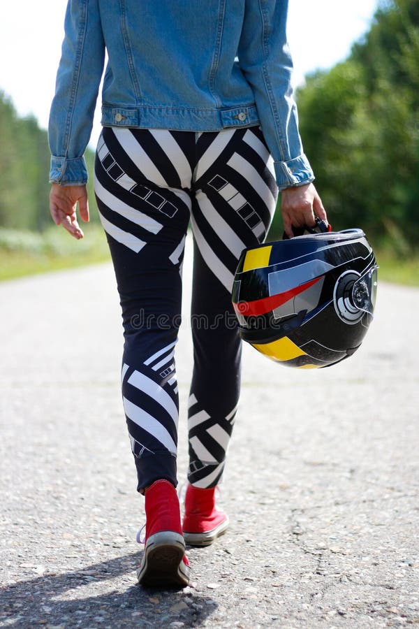Dziewczyna niesie motocyklu hełm w jego ręce Ty tylko widziisz fotografia stock Dziewczyna niesie motocyklu hełm w jego ręce Ty tylko widziisz fotografia stock