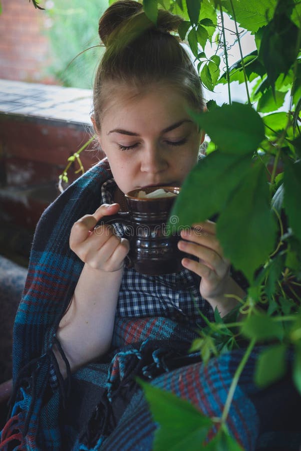 Dziewczyna pije kakao. Kaukaska młoda kobieta pije kakao z marshmallow