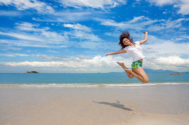 Young beautiful girl jumping gracefully on a beautiful day at the beach with beautiful clouds in the background. Young beautiful girl jumping gracefully on a beautiful day at the beach with beautiful clouds in the background