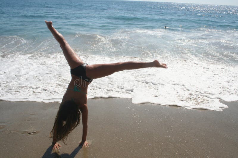 Dziewczyna Robi Cartwheel na plaży fotografia stock Dziewczyna Robi Cartwheel na plaży fotografia stock