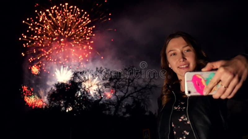 Dziewczyna robi selfie w telefonie podczas fajerwerków na nocnym niebie Wolny ruch