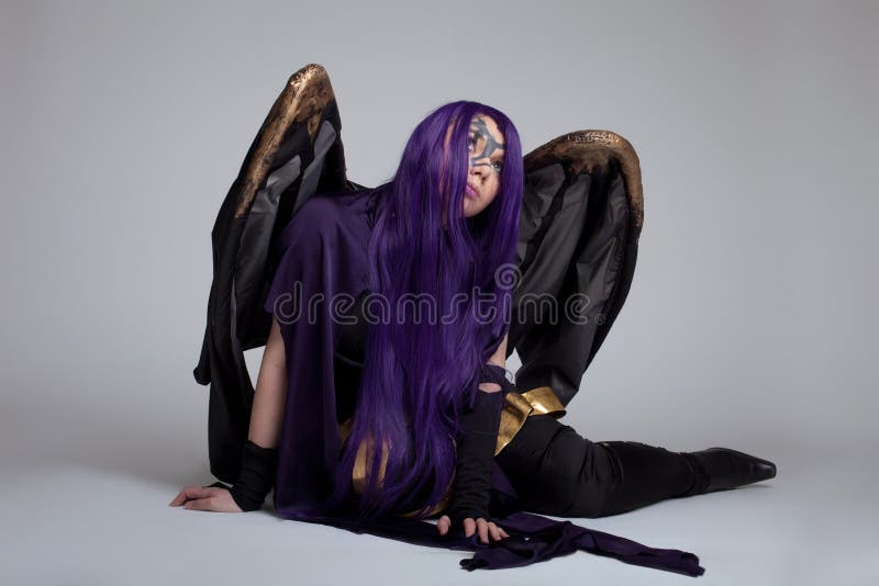 Dziewczyna siedzi w purpurowej wściekłości cosplay kostiumowym charakterze obrazy stock Dziewczyna siedzi w purpurowej wściekłości cosplay kostiumowym charakterze obrazy stock