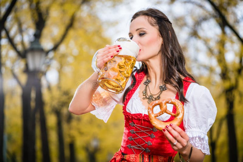 Dziewczyna w tradycyjnym bavarian Tracht pije piwo z ogromnego mu zdjęcia royalty free Dziewczyna w tradycyjnym bavarian Tracht pije piwo z ogromnego mu zdjęcia royalty free