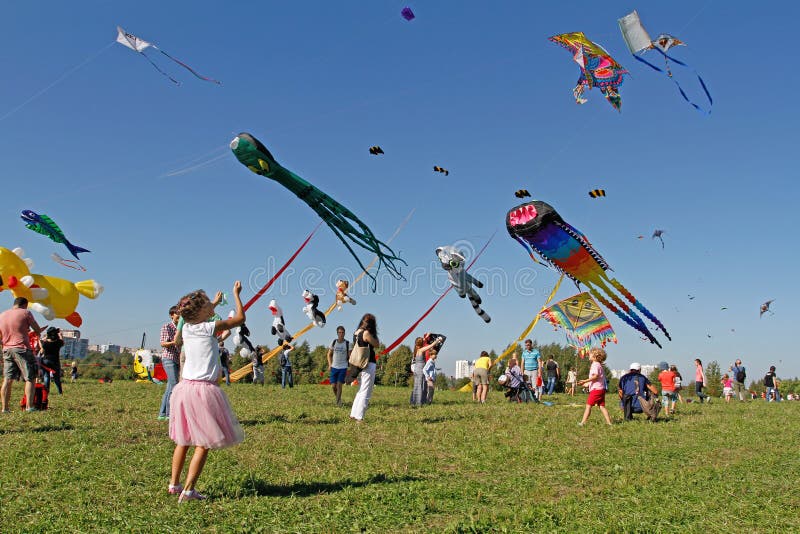 Dziewczyna wszczyna kanię w niebo przy kania festiwalem w Parkowym Tsaritsyno w Moskwa zdjęcie stock Dziewczyna wszczyna kanię w niebo przy kania festiwalem w Parkowym Tsaritsyno w Moskwa zdjęcie stock