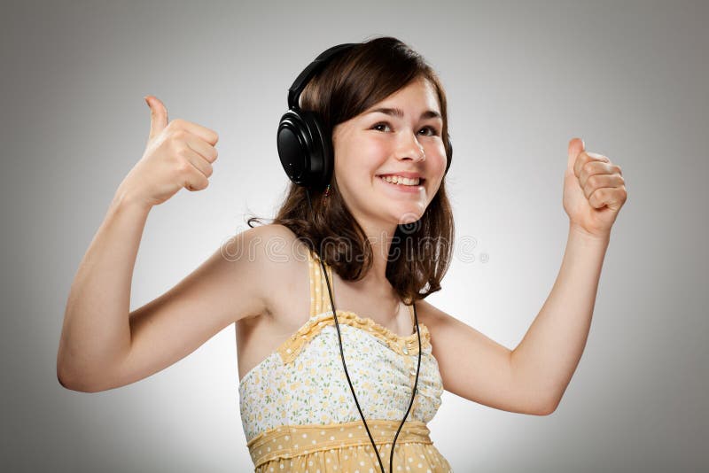 Girl with headphones on gray background. Girl with headphones on gray background
