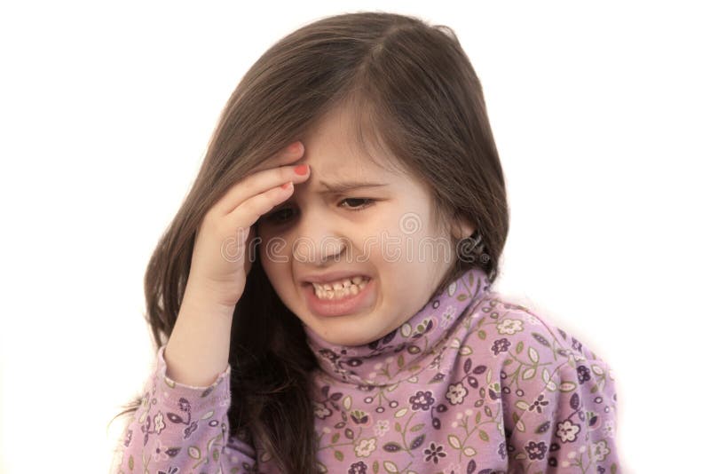 Cute little girl with her hand held to her forehead with painful expression showing headache. Cute little girl with her hand held to her forehead with painful expression showing headache