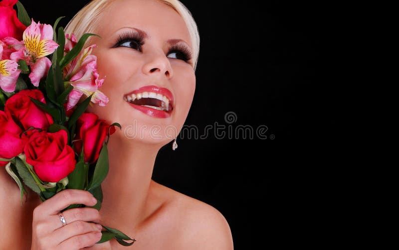 Dziewczyna z różami. szczęśliwa młoda kobieta z bukietem kwiaty nad czarnym tłem, pięknej blondynki uśmiechnięta dziewczyna