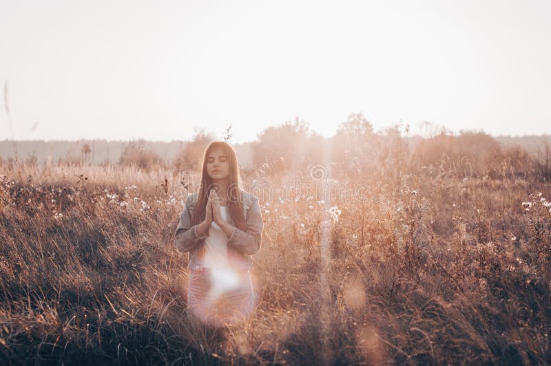 Girl closed her eyes, praying outdoors, Hands folded in prayer concept for faith, spirituality and religion. Peace, hope, dreams concept. Girl closed her eyes, praying outdoors, Hands folded in prayer concept for faith, spirituality and religion. Peace, hope, dreams concept.