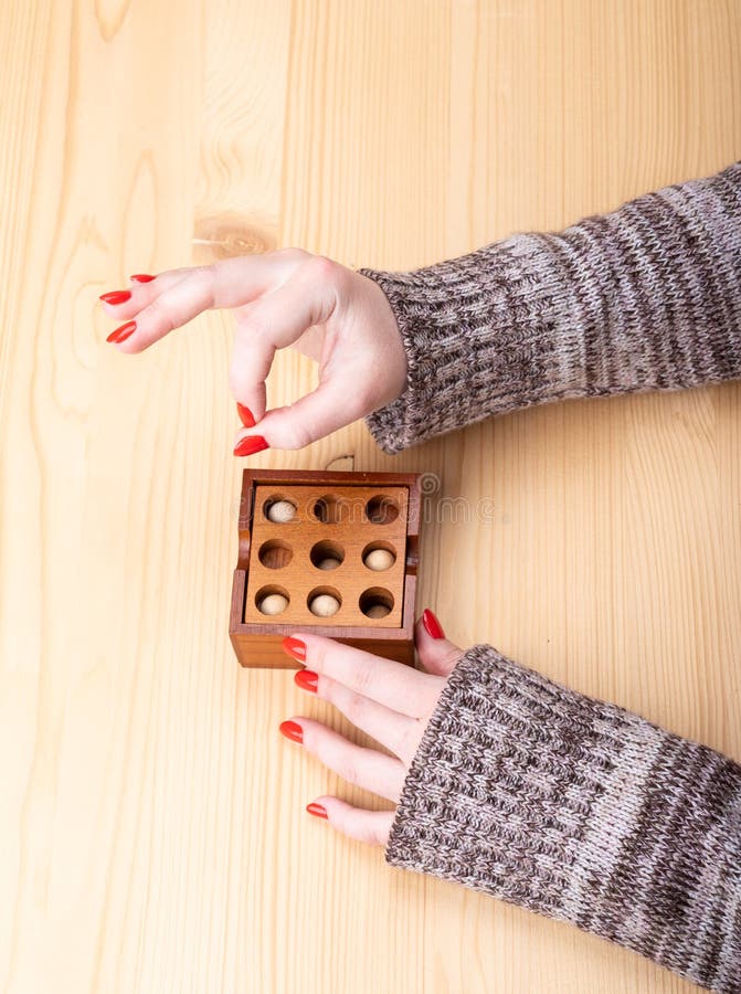 Dziewczynka po zebraniu puzzli pokazuje na palcach znak ok. Drewniane puzzle i dziury Jasna manicure na paznokciach Koncepcja układanki