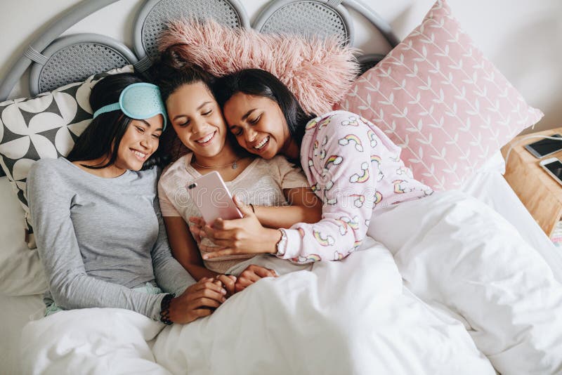 Dziewczyny cieszy się z telefonem komórkowym podczas sleepover obraz stock Dziewczyny cieszy się z telefonem komórkowym podczas sleepover obraz stock