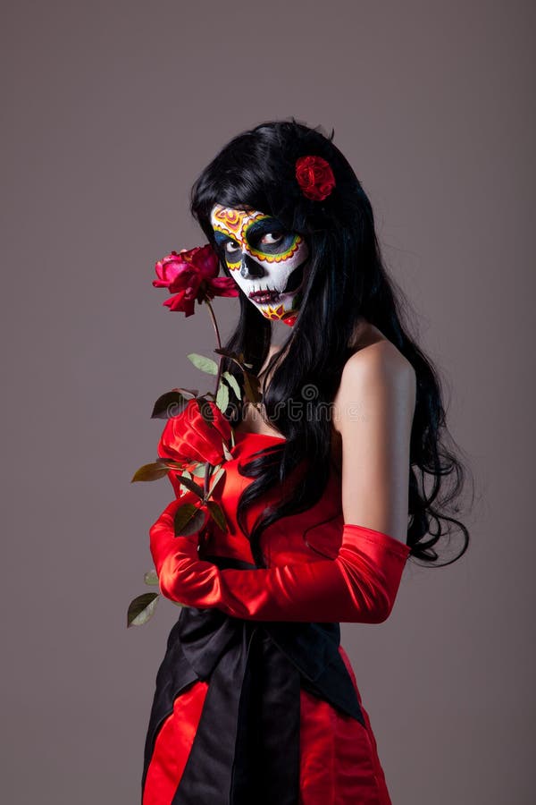 Sugar skull girl with red rose, studio shot. Sugar skull girl with red rose, studio shot