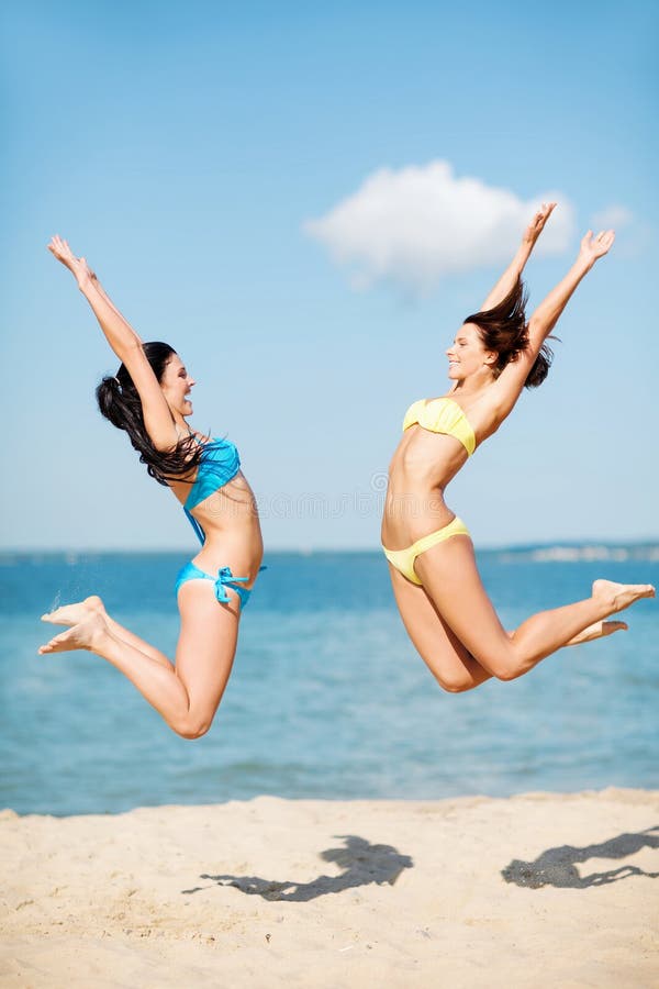 Summer holidays and vacation - girls jumping on the beach. Summer holidays and vacation - girls jumping on the beach