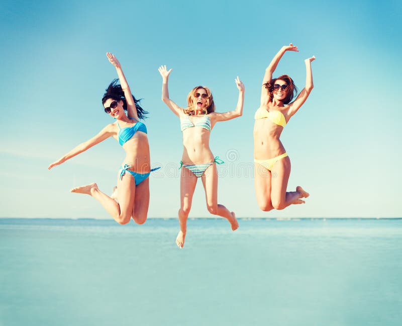 Summer holidays and vacation - girls jumping on the beach. Summer holidays and vacation - girls jumping on the beach