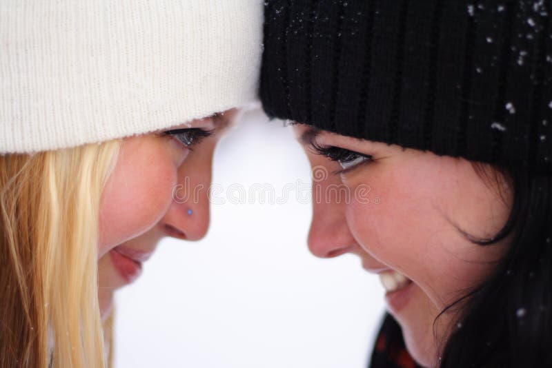 Two young happy girls looking each other in the eyes, close up. Two young happy girls looking each other in the eyes, close up