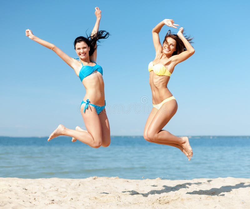 Summer holidays and vacation concept - beautiful girls in bikini jumping on the beach. Summer holidays and vacation concept - beautiful girls in bikini jumping on the beach