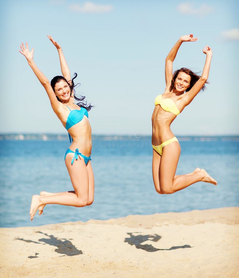 Summer holidays and vacation concept - beautiful girls in bikini jumping on the beach. Summer holidays and vacation concept - beautiful girls in bikini jumping on the beach