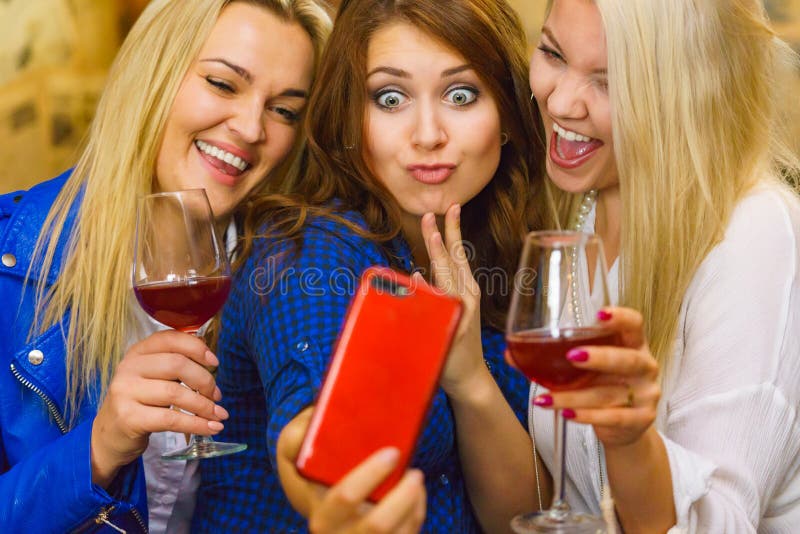Dziewczyny w klubie pub robią sobie zdjęcie z telefonu zdjęcia stock Dziewczyny w klubie pub robią sobie zdjęcie z telefonu zdjęcia stock